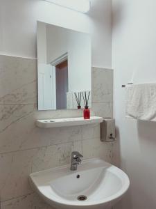 舒加塔格盐矿镇Pensiunea Ocna Maramuresului的浴室设有白色水槽和镜子