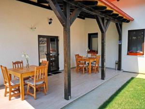 舒加塔格盐矿镇Pensiunea Ocna Maramuresului的一个带木桌和椅子的庭院和一间餐厅