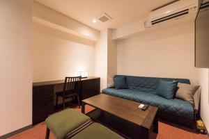 东京Serorin Light Hotel Tokyo的客厅配有蓝色的沙发和桌子