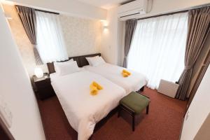 东京Serorin Light Hotel Tokyo的两张位于酒店客房的床,上面有黄色的毛巾