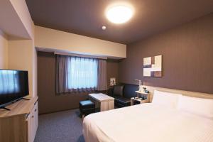 铫子市Hotel Route Inn Choshi Eki Nishi的酒店客房,配有床和电视