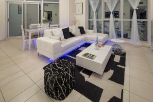迪拜Torch 77的客厅配有白色的沙发和桌子