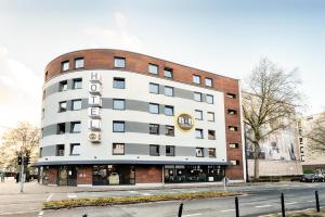 不莱梅B&B Hotel Bremen-City的白色的建筑,旁边标有标志