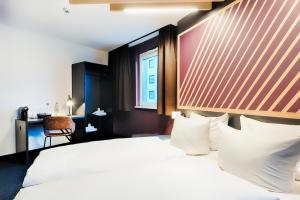 不莱梅B&B Hotel Bremen-City的一间设有大床和窗户的酒店客房