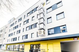 波恩B&B Hotel Bonn-West的白色的大建筑,设有黄色的门窗