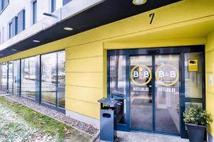 波恩B&B Hotel Bonn-West的门上带有安全标志的黄色建筑