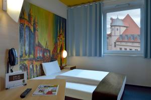 爱尔福特B&B HOTEL Erfurt-Hbf的酒店客房设有床和窗户。