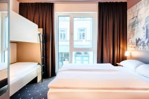艾森纳赫B&B Hotel Eisenach的酒店客房设有两张床和窗户。
