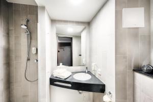 波鸿B&B Hotel Bochum-City的一间带水槽和淋浴的浴室