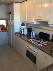 莫莱拉Apartment Kristal Mar的厨房配有白色橱柜和炉灶烤箱。