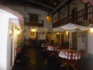 库斯科绿色酒店的一间带桌椅和遮阳伞的餐厅