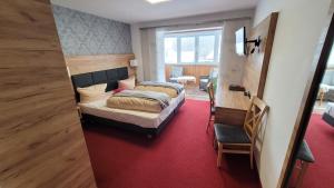罗滕堡斯齐瓦尔兹拉姆酒店的一间卧室配有两张床,铺有红地毯