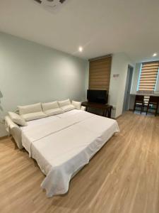 Kelebang BesarCT HOME83Stay - Klebang Beach Melaka的铺有木地板的客房内一张大白色的床