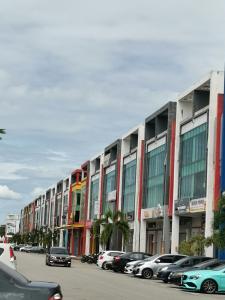 Kelebang BesarCT HOME83Stay - Klebang Beach Melaka的停车场内一排有汽车的建筑