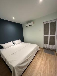 Kelebang BesarCT HOME83Stay - Klebang Beach Melaka的卧室配有一张白色大床和蓝色的墙壁