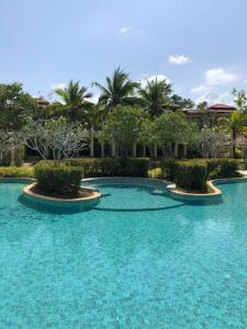 拉扬海滩度Phuket Laguna Beach - Big Family Pool Villa 2 Extra Large bedrooms的一座拥有蓝色海水和棕榈树的游泳池