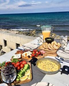 AyyorgiHigh By The Beach House in Girne的一张桌子,桌子上放着食物,靠近大海