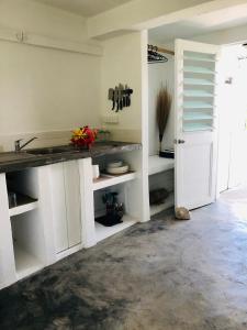 维拉港Banana Bay Beach Club的厨房配有白色橱柜和台面
