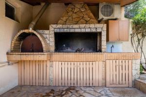 凯法利尼亚岛Panos Apartment的一个带石头壁炉的户外比萨饼烤箱