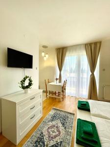 凯斯特海伊Libás Apartman的一间卧室配有一张床、一张桌子和一台电视