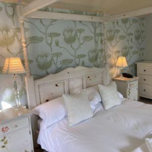 Feetham旁池碗旅馆的卧室配有一张白色床、两张桌子和两盏灯。