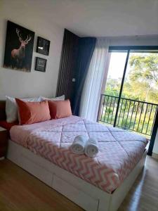 华欣Cozy resort-style condominium的一间卧室设有一张床,享有窗户的景色