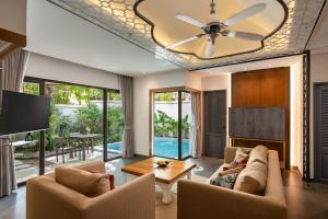 奈扬海滩Dewa Phuket Resort & Villas的带沙发和吊扇的客厅