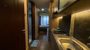 巴淡岛中心Meisterstadt Pollux Habibie Apartment by uhomeid的一间带水槽和镜子的浴室以及一张床