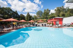 巴特格里斯巴赫圣沃尔夫冈酒店的游泳池,带椅子和遮阳伞