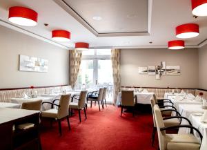 巴特格里斯巴赫圣沃尔夫冈酒店的一间设有白色桌椅的用餐室