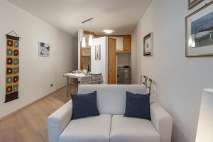 普雷达佐DolomiApartments - Appartamento Orso Bruno的一间带白色沙发的客厅和一间厨房