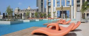 迪拜Spacious 3BDR Apartment and maid room with Burj Khalifa View的一座建筑前的游泳池,里面装有橙色充气剂