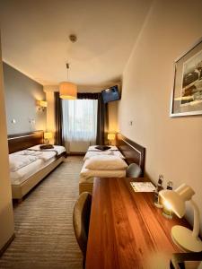 别尔斯克-比亚拉Hotel Szyndzielnia Eco的酒店客房设有两张床和一张木桌。