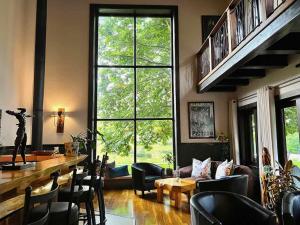 安德伯格Malachite Manor的客厅配有桌椅和大窗户