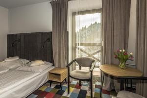 克雷尼察OSW Pan Tadeusz的卧室配有床、椅子和窗户。
