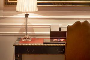 佛罗伦萨佛罗伦萨瑞吉酒店的一张桌子,上面有台灯和盒子