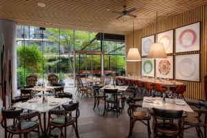 利马Hyatt Centric San Isidro Lima的餐厅设有桌椅和大窗户。
