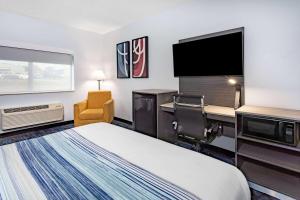 昆西AmericInn by Wyndham Quincy的配有一张床和一台平面电视的酒店客房
