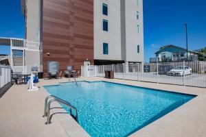 加尔维斯敦La Quinta Inn & Suites by Wyndham Galveston North at I-45的大楼前的游泳池