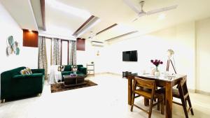 新德里橄榄服务公寓 - 格林公园的客厅配有桌子和绿色沙发
