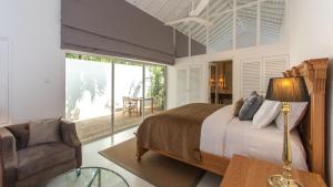 坦加拉Maya Tangalle的卧室配有床、椅子和窗户。
