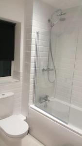 欣克利Lovely 1-Bedroom Flat in Hinckley, LE10的带淋浴和卫生间的白色浴室