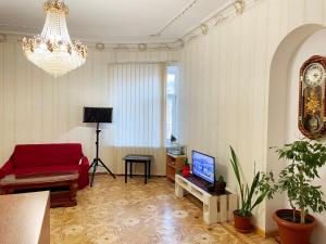 敖德萨DAY & NIGHT的客厅配有红色沙发和吊灯