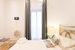 罗马威尼斯广场公寓及露台的卧室配有床、椅子和窗户。