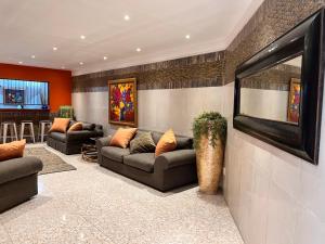 比勒陀利亚Solitaire Guest Apartments的客厅配有两张沙发和一台电视