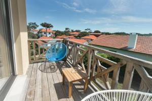 米尼赞海滩Single Fin Hotel & Lodge的一张蓝色椅子,坐在木甲板上