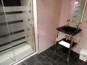 比亚雷亚尔Hello Villarreal Suites的一间带水槽和玻璃淋浴的浴室