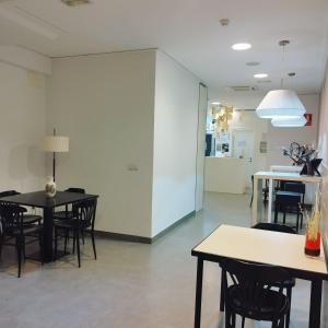 比亚雷亚尔Hello Villarreal Pension的一间设有桌椅和白色墙壁的用餐室