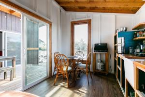 KehenaTHE OHANA HOUSE, Amazing Tiny Home on A Volcanic Lava Field!的厨房配有桌椅和窗户。