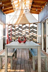 KehenaTHE OHANA HOUSE, Amazing Tiny Home on A Volcanic Lava Field!的木甲板上配有长凳的野餐桌